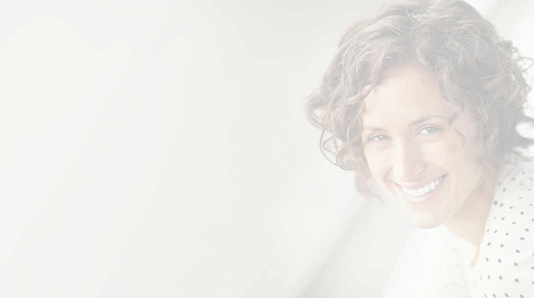 Smiling woman with curly hair leaning on railing
