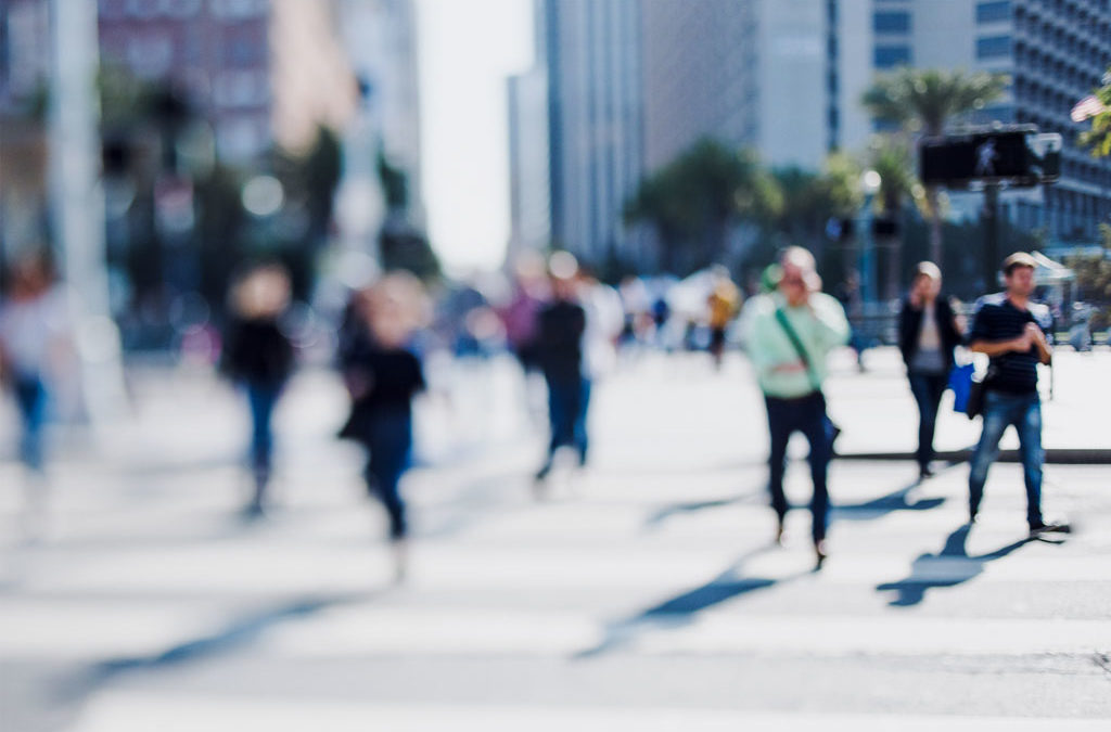 Blurry pedestrians crossing busy downtown city street