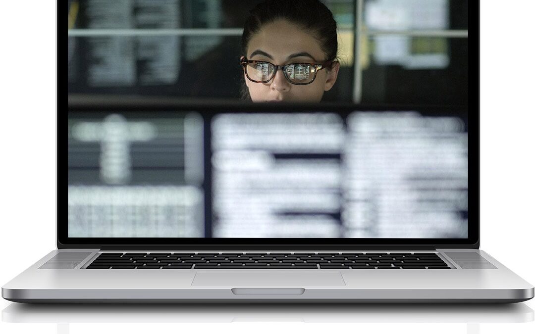 Programmer with glasses viewing code on laptop