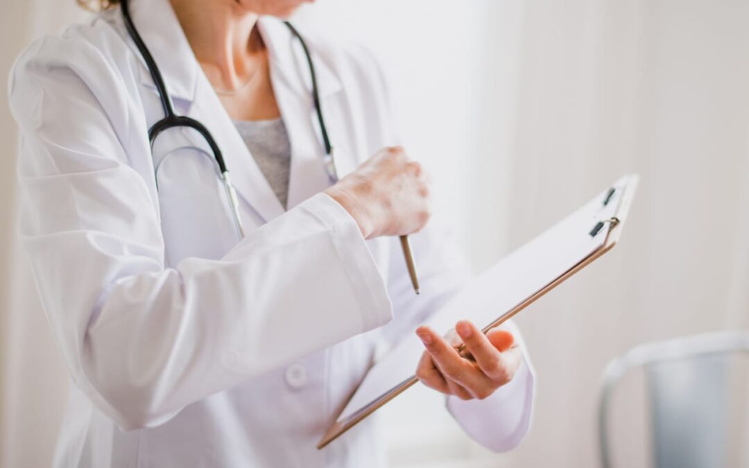 Doctor writing on clipboard with stethoscope